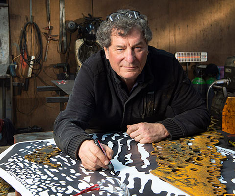 Marco Käller aan het werk met een cortenstalen beeld.